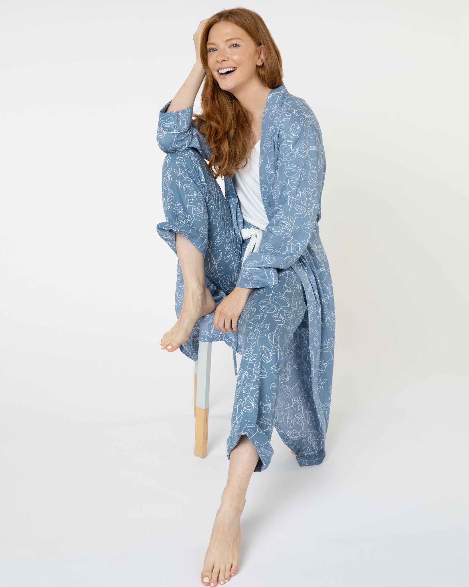 Woman wearing blue and white floral luxury organic cotton dressing gown from Yawn.