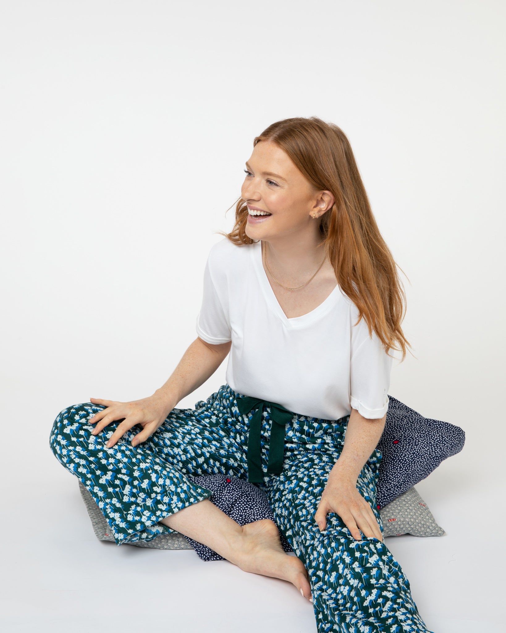 Woman wearing green floral luxury organic cotton pyjama bottoms from Yawn.